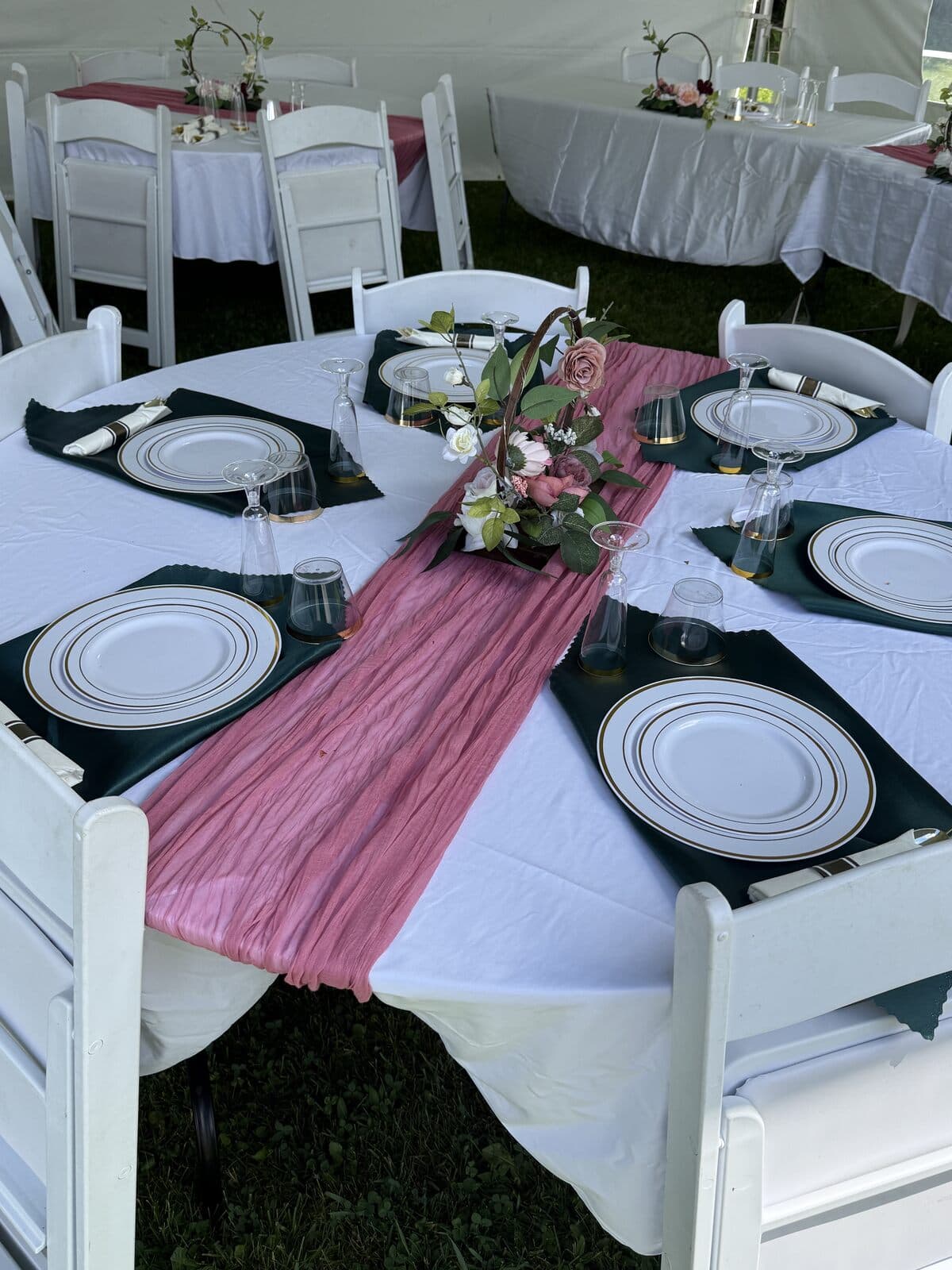 Tablescape detail with a rose runner, plates, and glassware